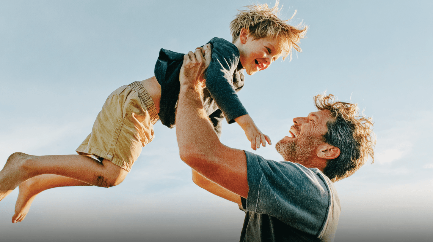 Father lifting his son outdoors - representing energy and vitality