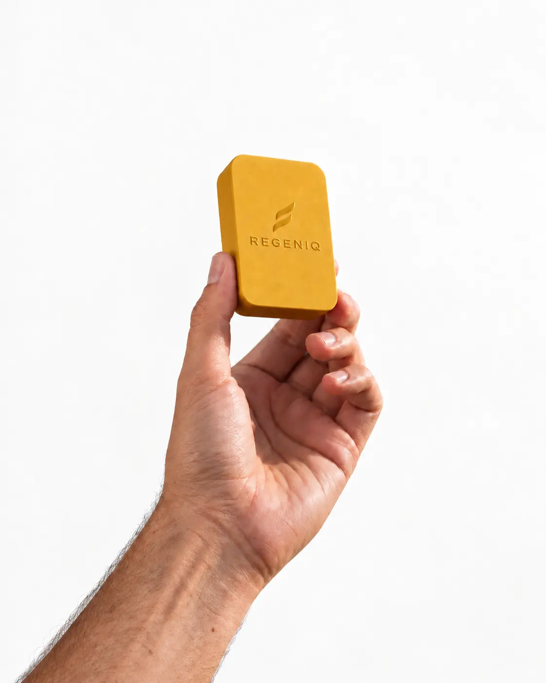 A hand holding a yellow Regeniq case embossed with the logo against a plain white background
