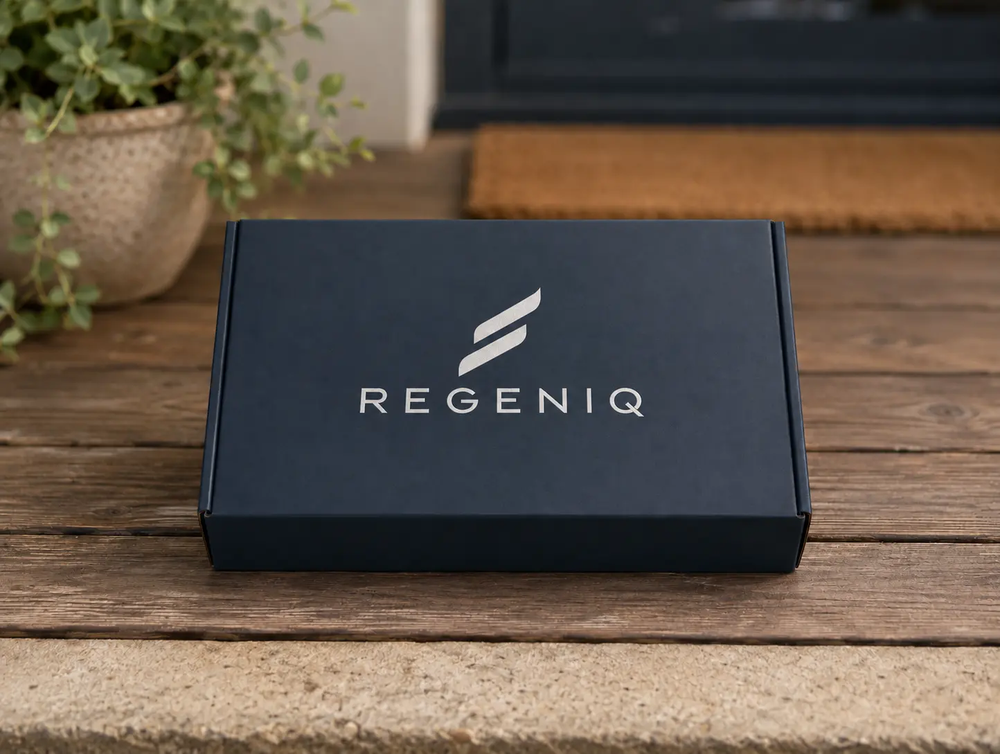 A plain navy Regeniq box resting on a doorstep