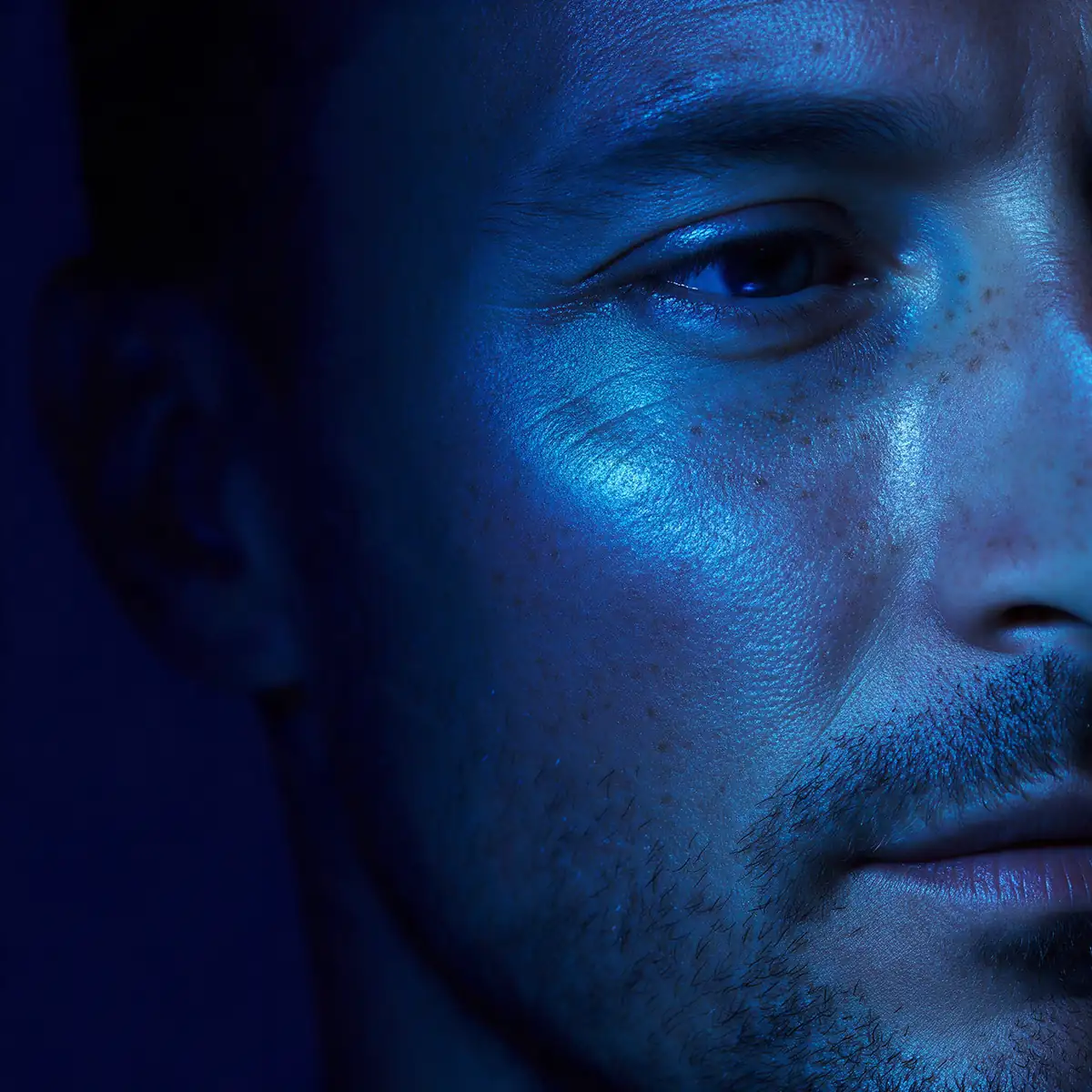 close-up of male skin with natural pores and fine lines in blue light